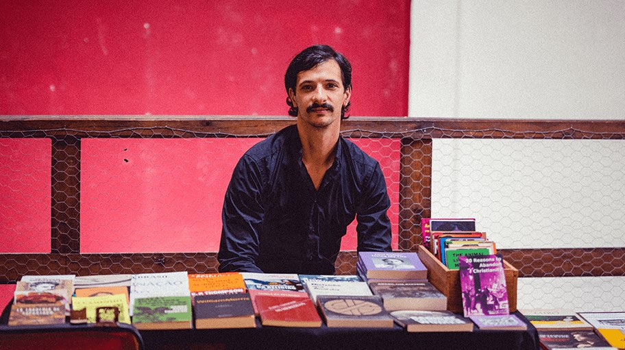 Vendedor sentado atrás de uma banca de livros